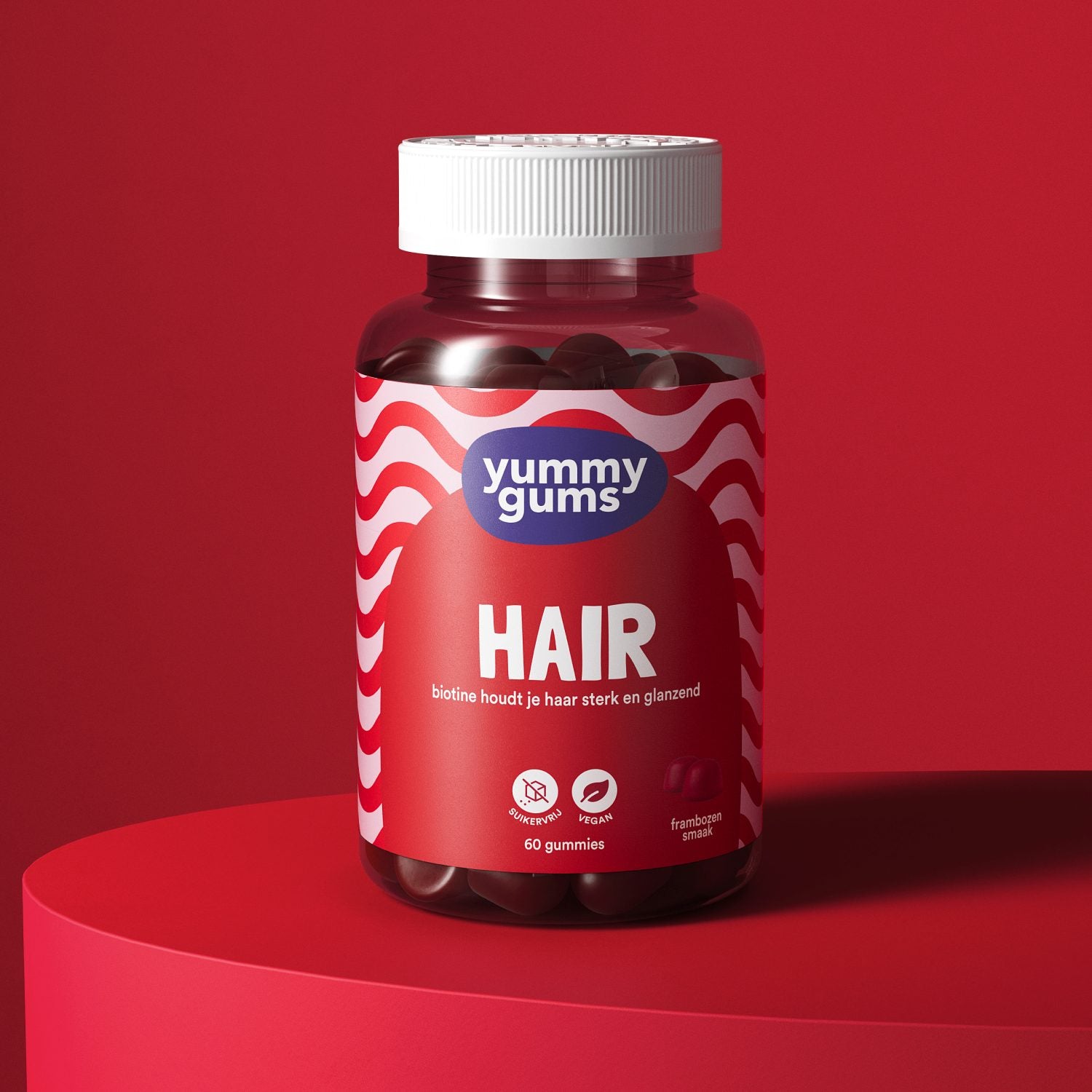 Pot met haarvitamine gummies van Yummy Gums, met frambozensmaak en een rood-wit golvend etiket.