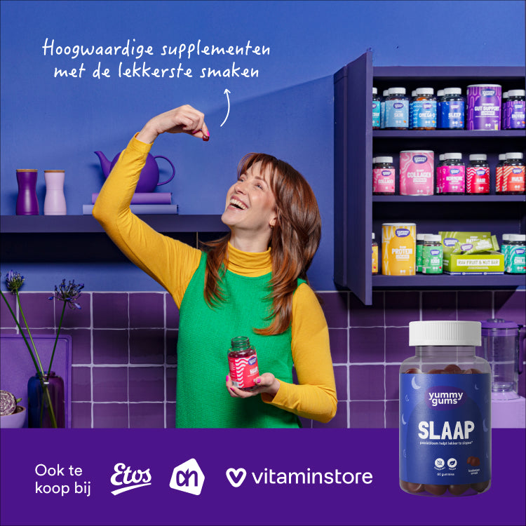 Een lachende vrouw in een groene jurk houdt een flesje Yummygums Slaap Gummies vast en maakt zich klaar om er een op te eten in een levendige paarse keuken. De tekst luidt: Hoogwaardige supplementen met de lekkerste smaken.